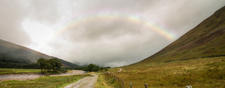 Rough winding path, with faint rainbow in distance