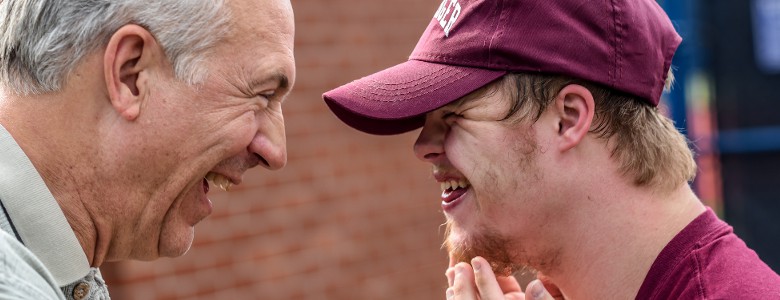 An Older Man and a Man with Downs Syndrome laugh together